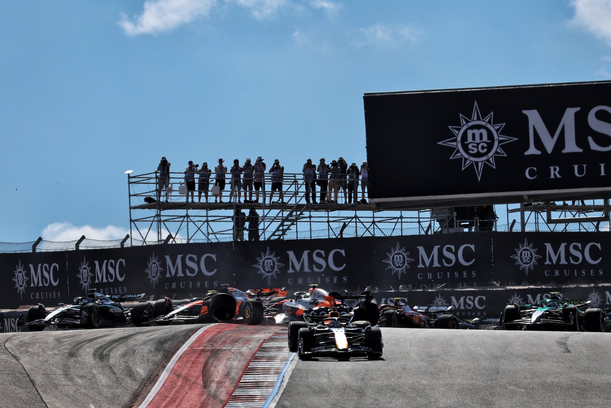 Max Verstappen (NLD) Red Bull Racing RB21 leads as Oscar Piastri (AUS) McLaren MCL39 and Lando Norris (GBR) McLaren MCL39 crash at the start of the race.