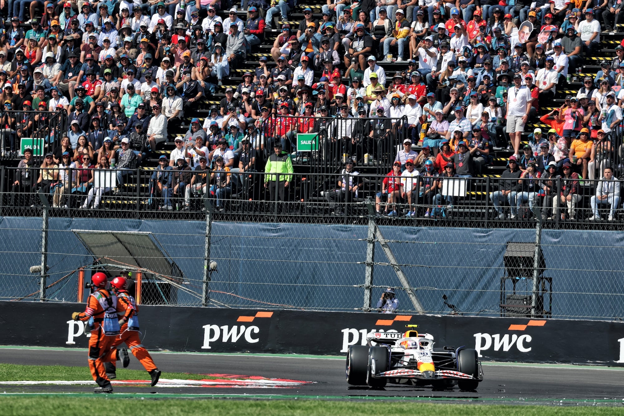 Marshals remove debris from the circuit as Liam Lawson (NZL) Racing Bulls VCARB 02 approaches.
