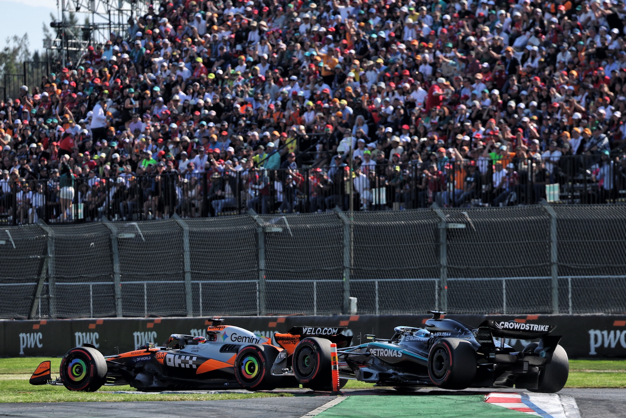 George Russell (GBR) Mercedes AMG F1 W16 and Oscar Piastri (AUS) McLaren MCL39 battle for position.