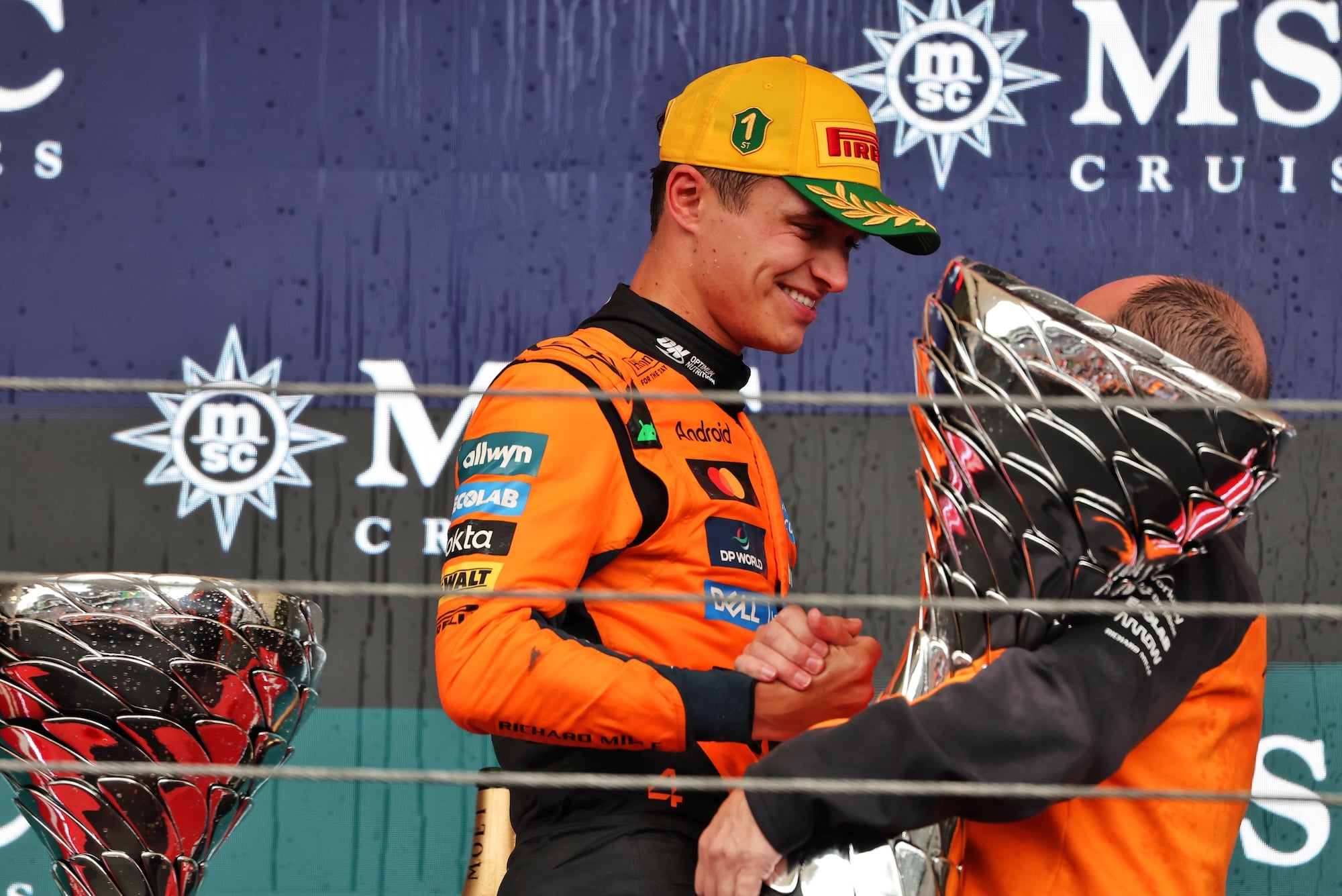 F1: Norris é primeiro piloto a ter 11 primeiras vitórias em 11 circuitos diferentes (L to R): Race winner Lando Norris (GBR) McLaren celebrates on the podium with Mark Norris (GBR) McLaren Director of Commercial Trackside Operations.