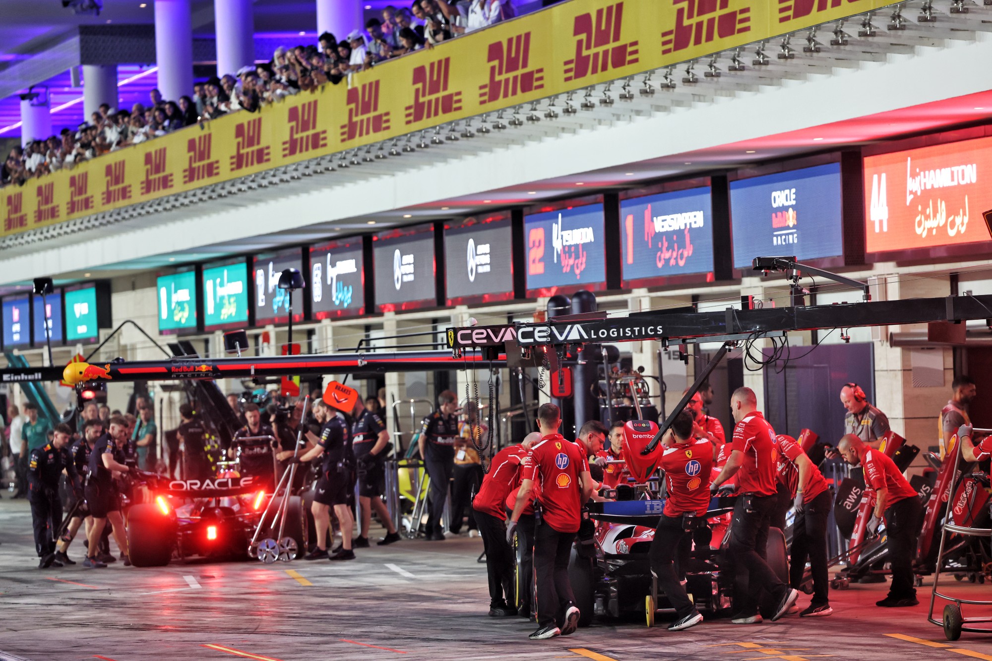 Yuki Tsunoda (JPN) Red Bull Racing RB21 and Charles Leclerc (MON) Ferrari SF-25 in the pits.