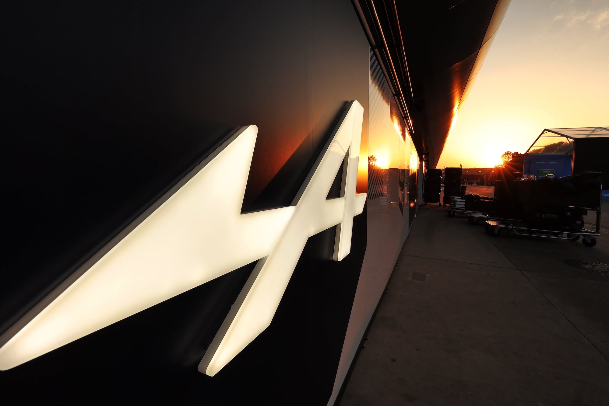 Paddock atmosphere - Alpine F1 Team logo at sunset.