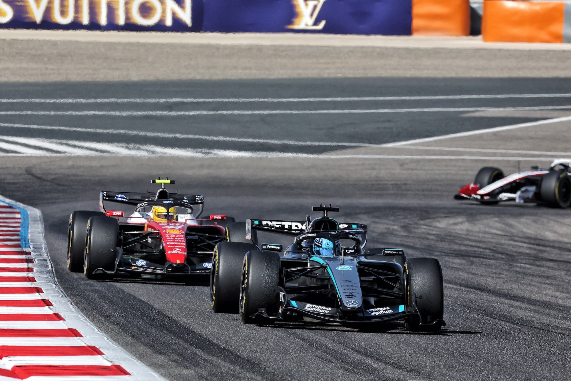 George Russell (GBR) Mercedes AMG Formula One Team W17 leads Lewis Hamilton (GBR) Scuderia Ferrari SF-26.