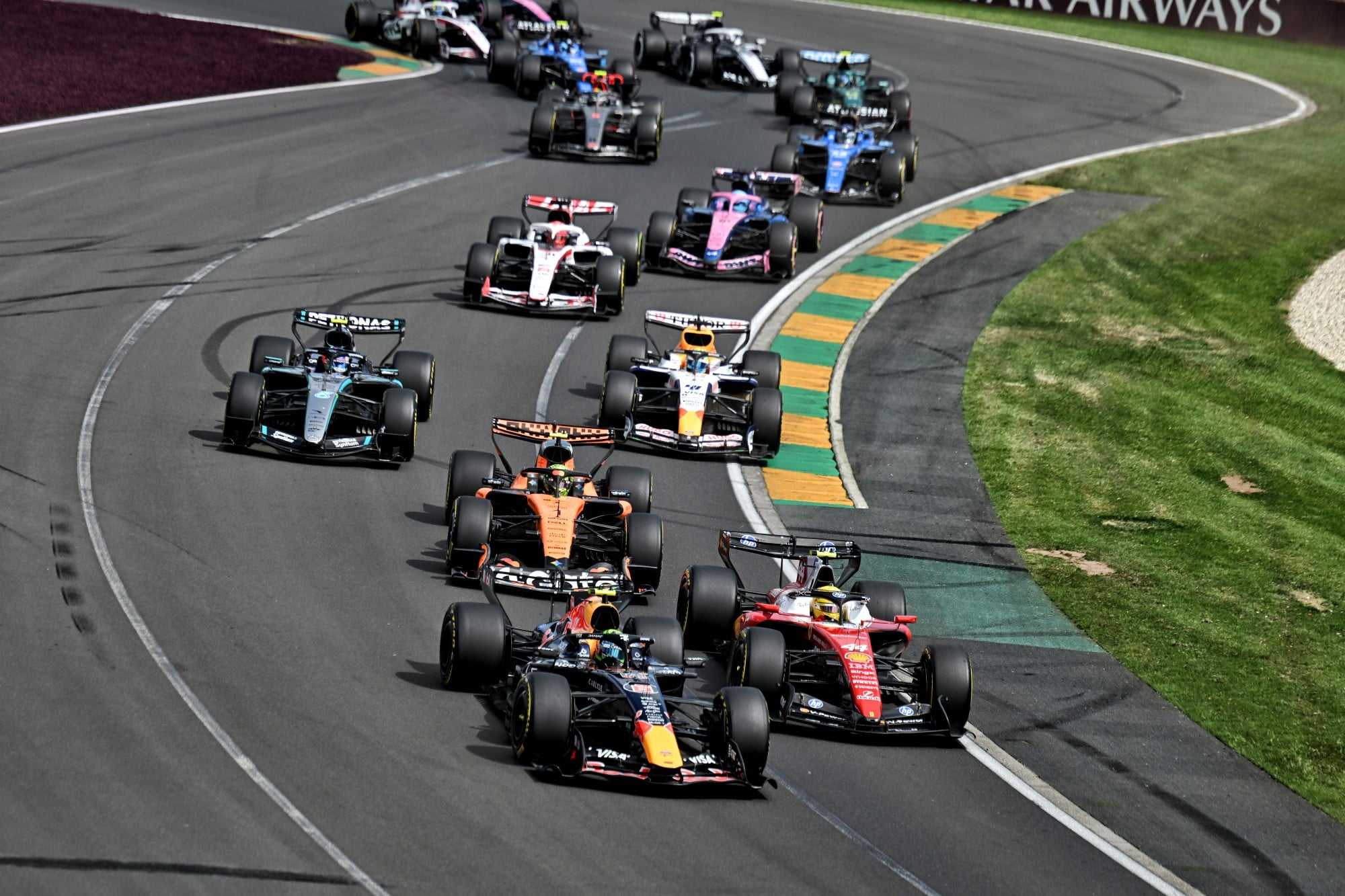 Isack Hadjar (FRA) Red Bull Racing RB22 and Lewis Hamilton (GBR) Scuderia Ferrari SF-26 at the start of the race.