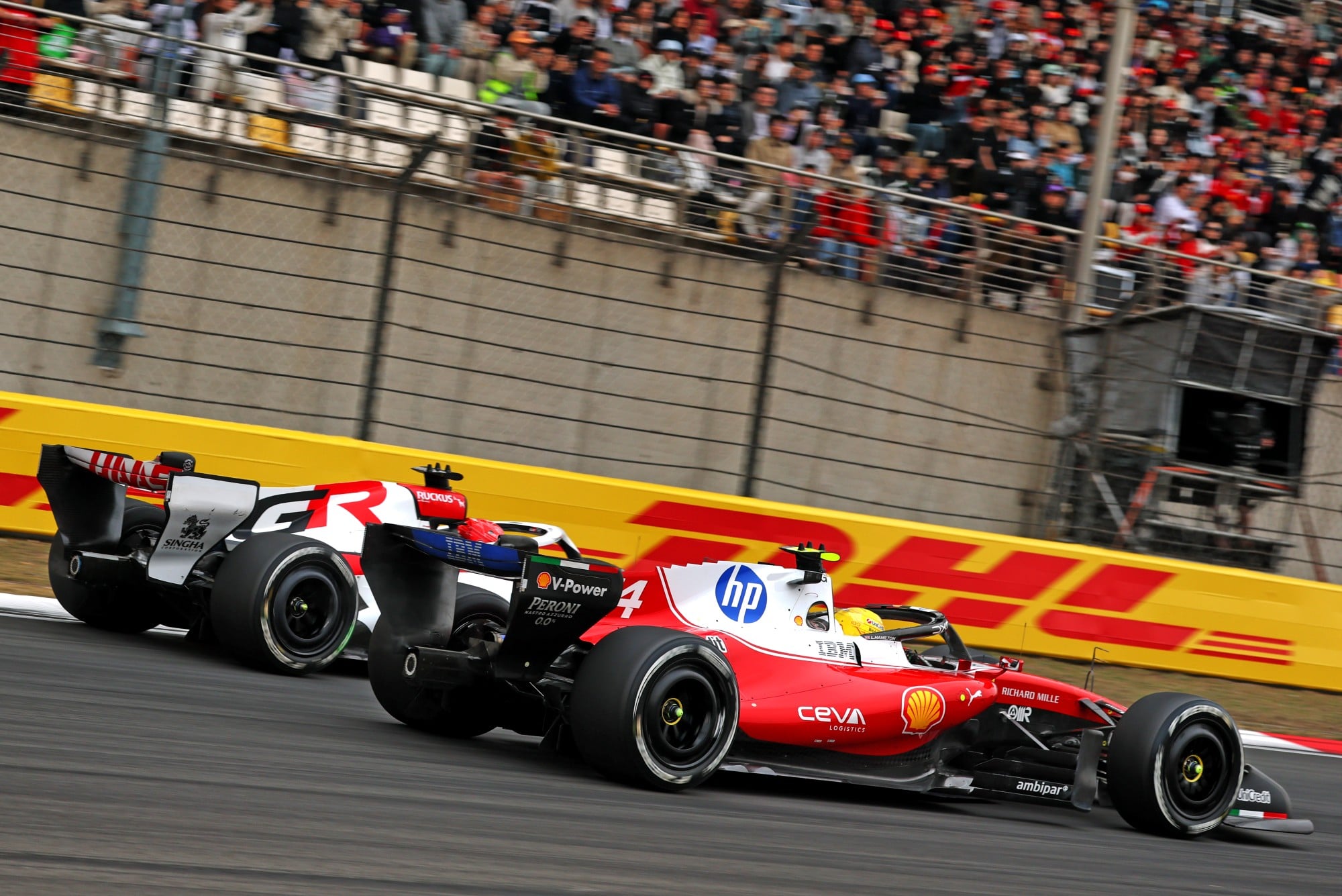F1: Confira as imagens do GP da China 2026 Lewis Hamilton (GBR) Scuderia Ferrari SF-26 and Esteban Ocon (FRA) Haas F1 Team VF-26 battle for position.