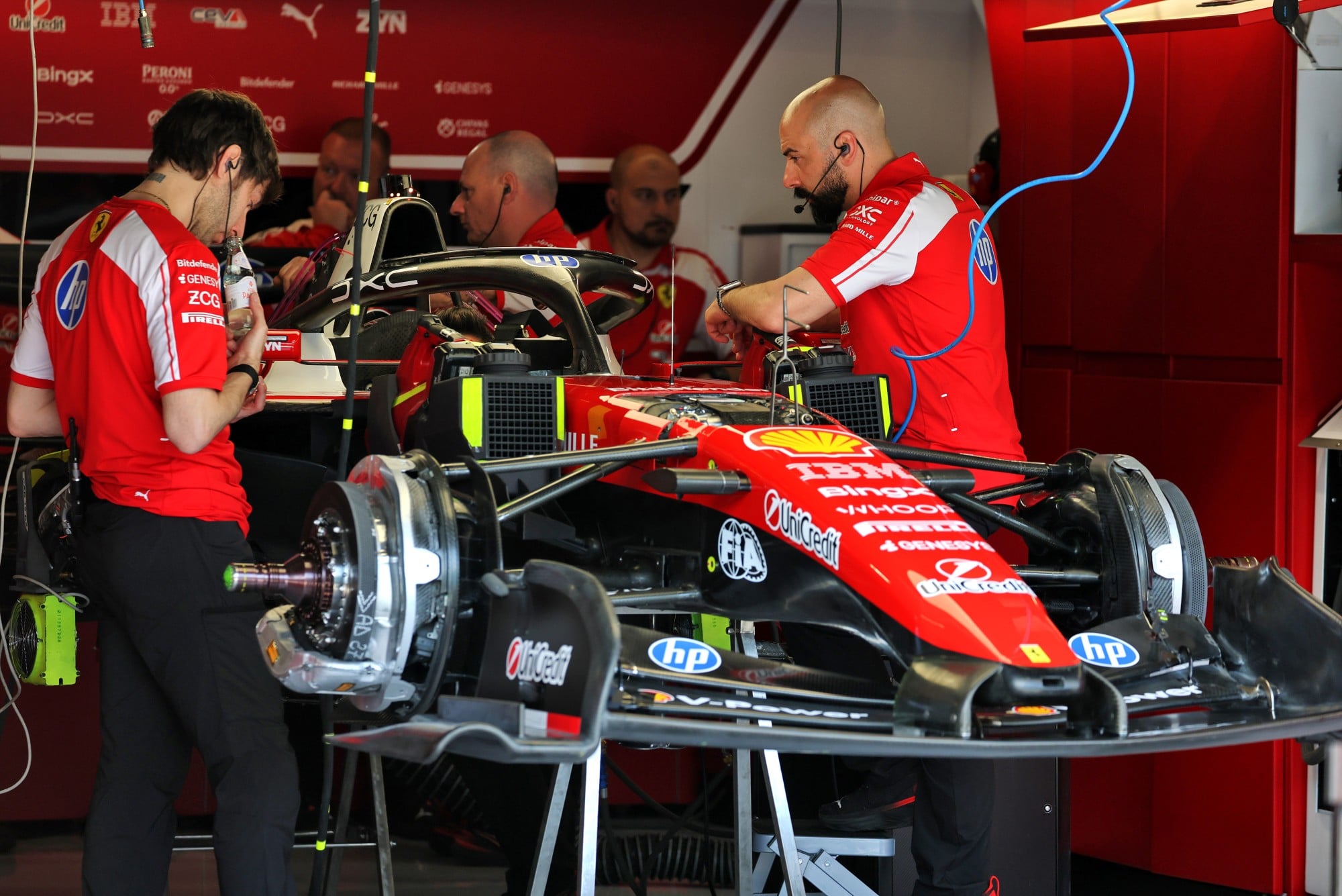 Scuderia Ferrari SF-26 prepared by mechanics in the pit garage.