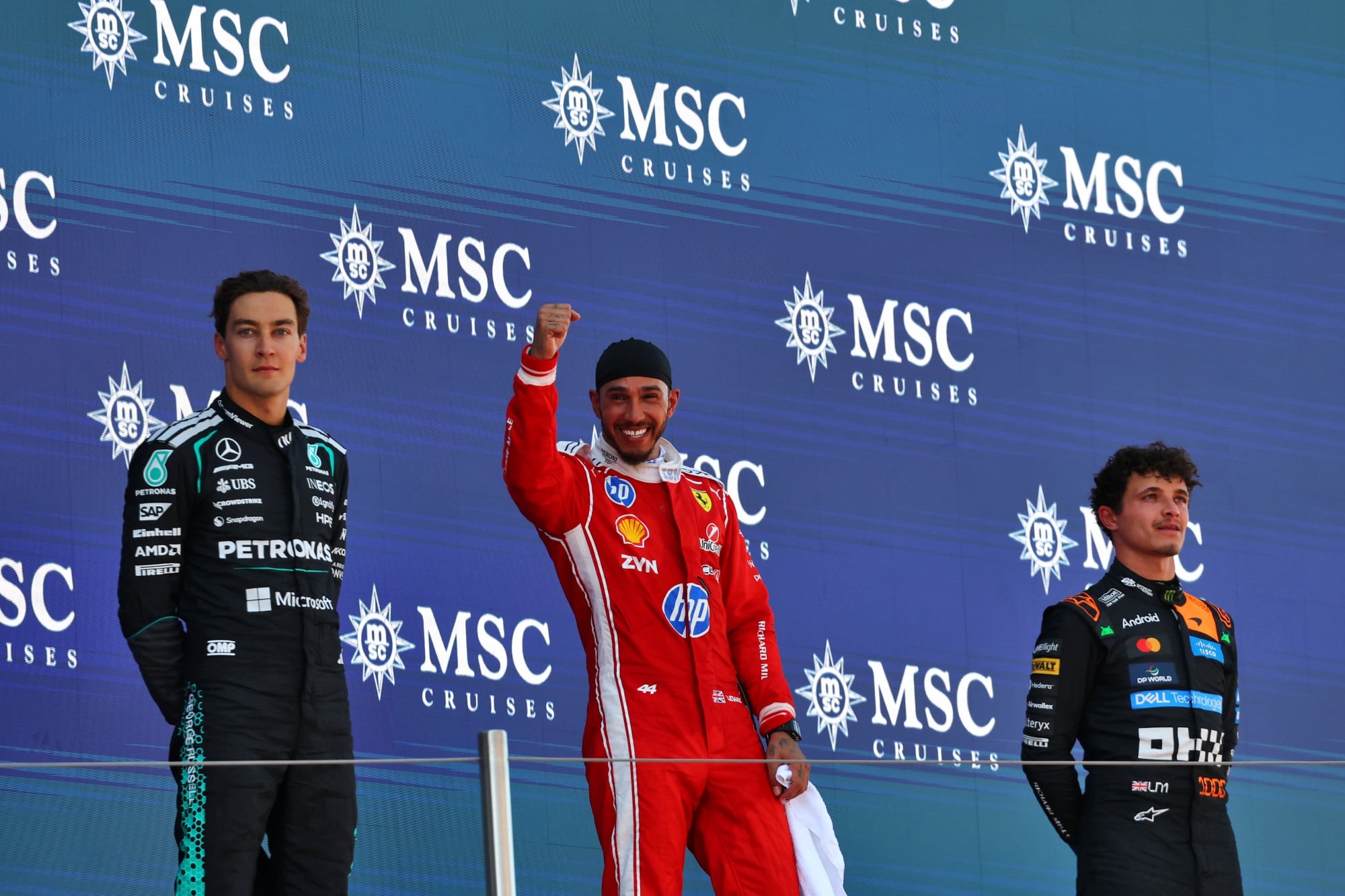 F1: Confira as imagens do GP de Barcelona 2026 The podium (L to R): grup, second; Lewis Hamilton (GBR) Scuderia Ferrari, race winner; Lando Norris (GBR) McLaren F1 Team, third.