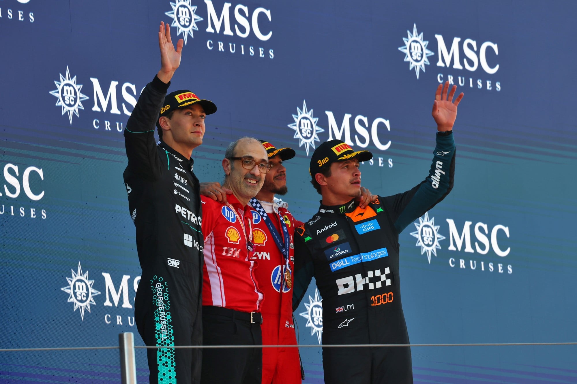 F1: Confira as imagens do GP de Barcelona 2026 The podium (L to R): George Russell (GBR) Mercedes AMG Formula One Team, second; Carlo Santi (ITA) Scuderia Ferrari Race Engineer; Lewis Hamilton (GBR) Scuderia Ferrari, race winner; Lando Norris (GBR) McLaren F1 Team, third.