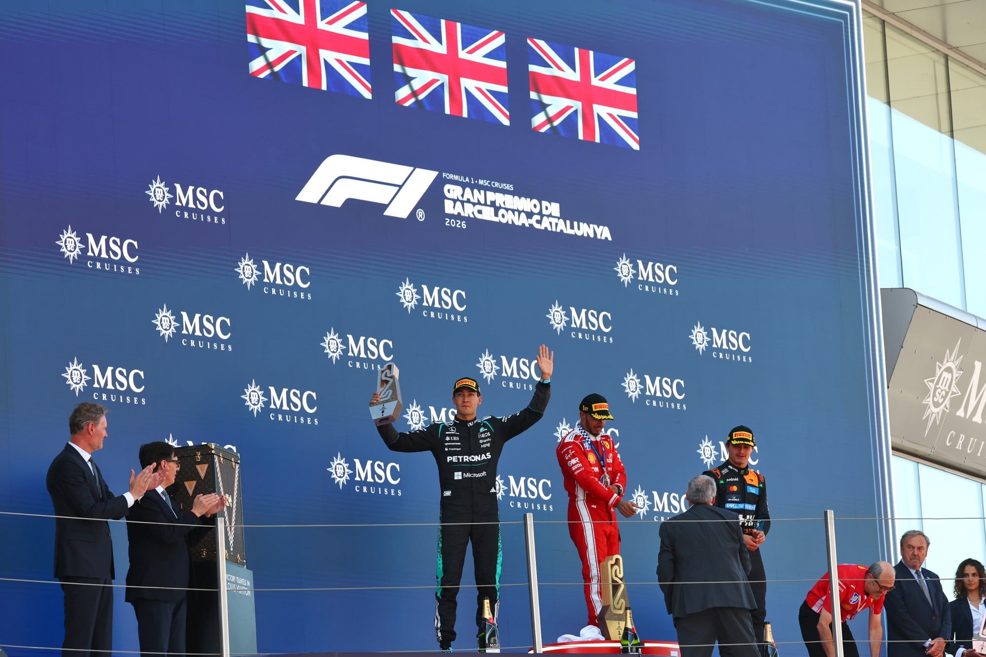 F1: Confira as imagens do GP de Barcelona 2026 The podium (L to R): George Russell (GBR) Mercedes AMG Formula One Team, second; Lewis Hamilton (GBR) Scuderia Ferrari, race winner; Lando Norris (GBR) McLaren F1 Team, third.