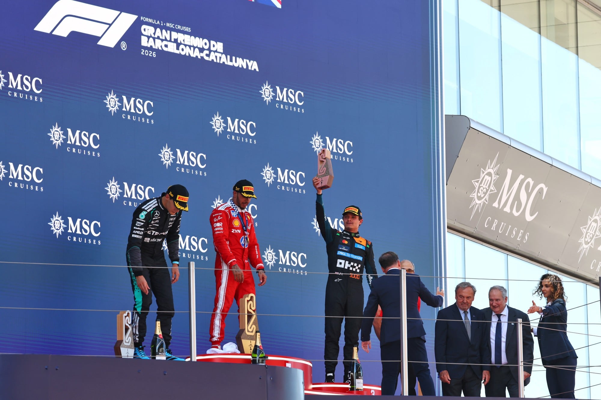 F1: Confira as imagens do GP de Barcelona 2026 The podium (L to R): George Russell (GBR) Mercedes AMG Formula One Team, second; Lewis Hamilton (GBR) Scuderia Ferrari, race winner; Lando Norris (GBR) McLaren F1 Team, third.