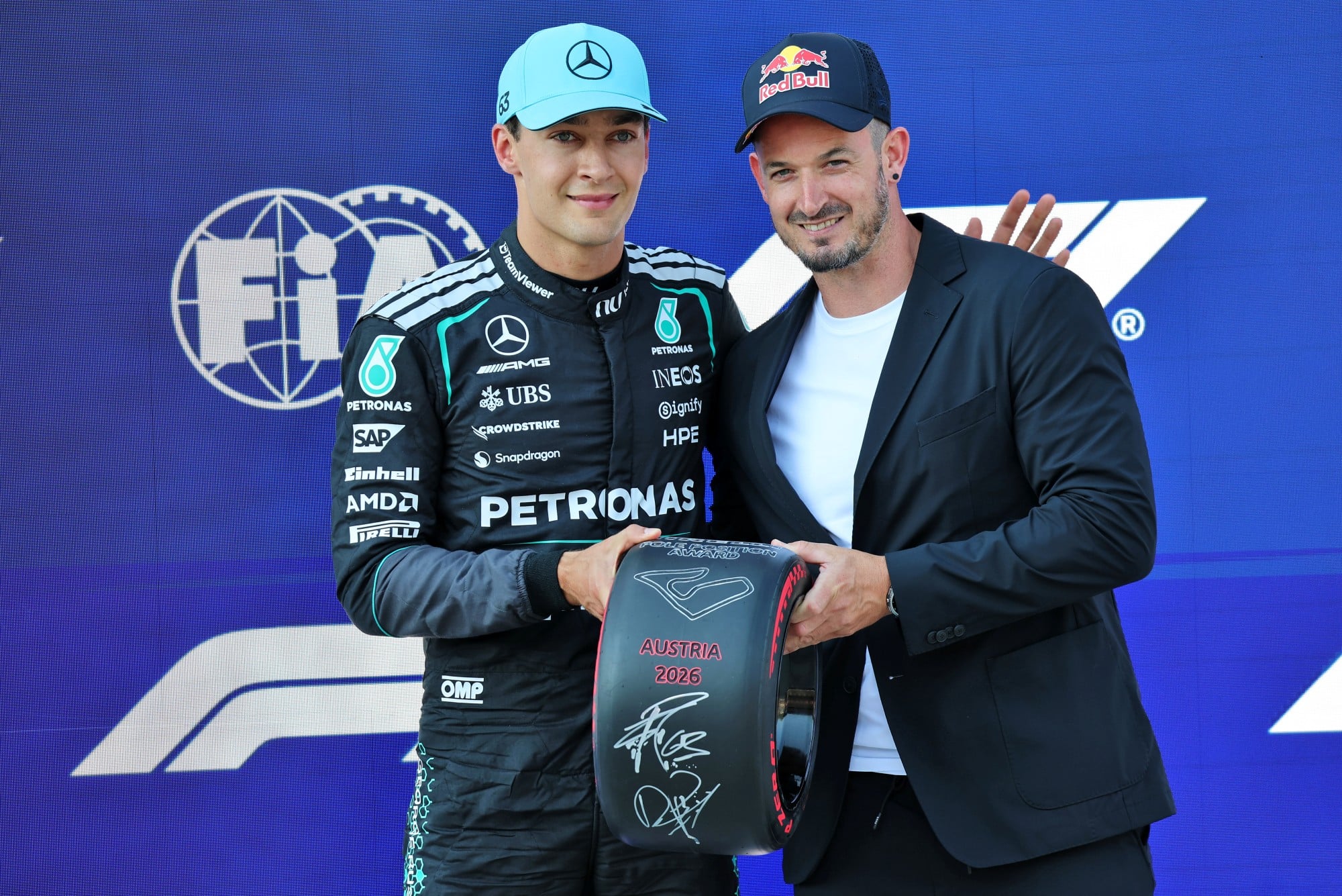(L to R): George Russell (GBR) Mercedes AMG Formula One Team receives the Pirelli Pole Position Award in qualifying parc ferme from Dominik Paris (ITA) Alpine Skiier.