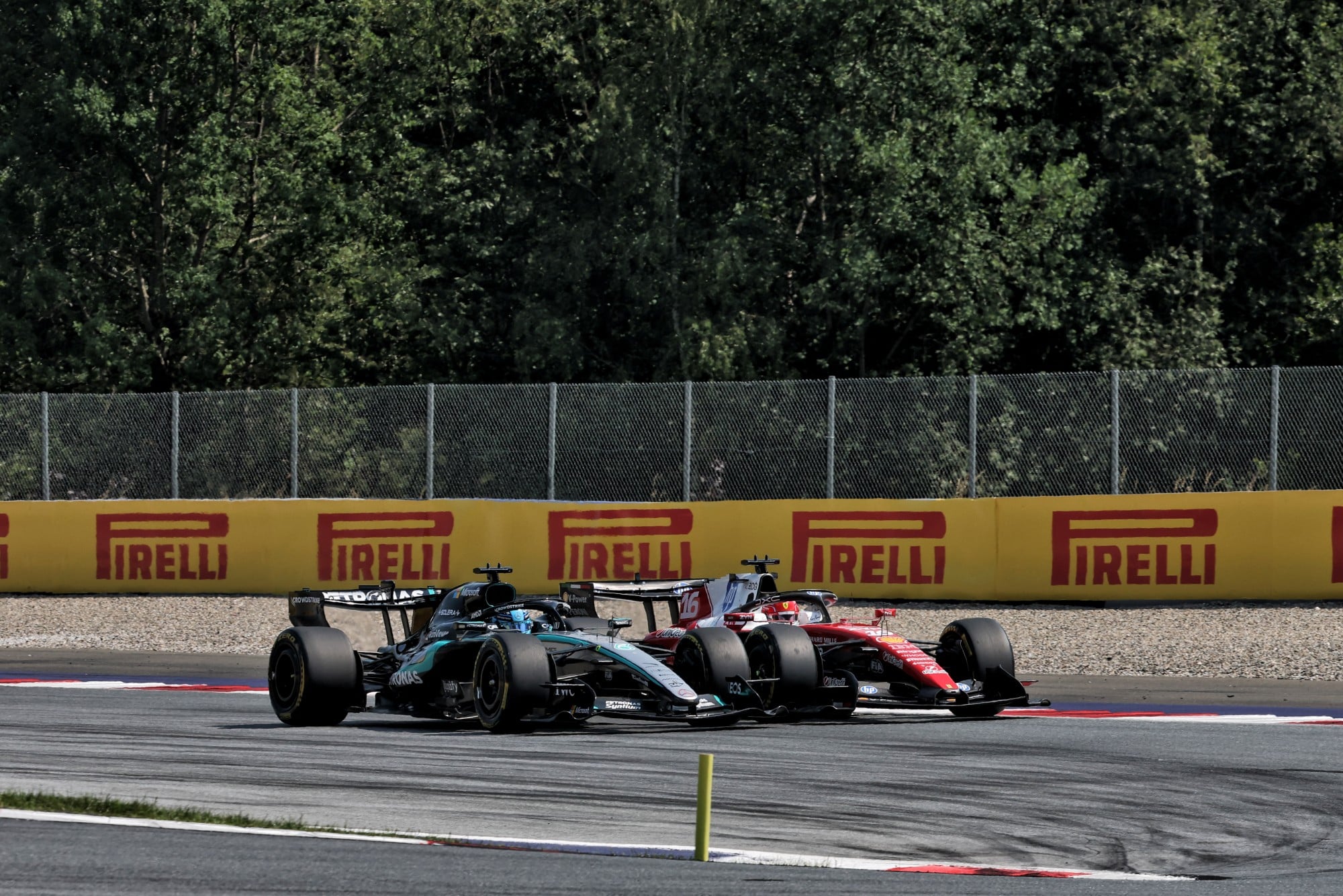 George Russell (GBR) Mercedes AMG Formula One Team W17 leads Charles Leclerc (MON) Scuderia Ferrari SF-26 at the start of the race.