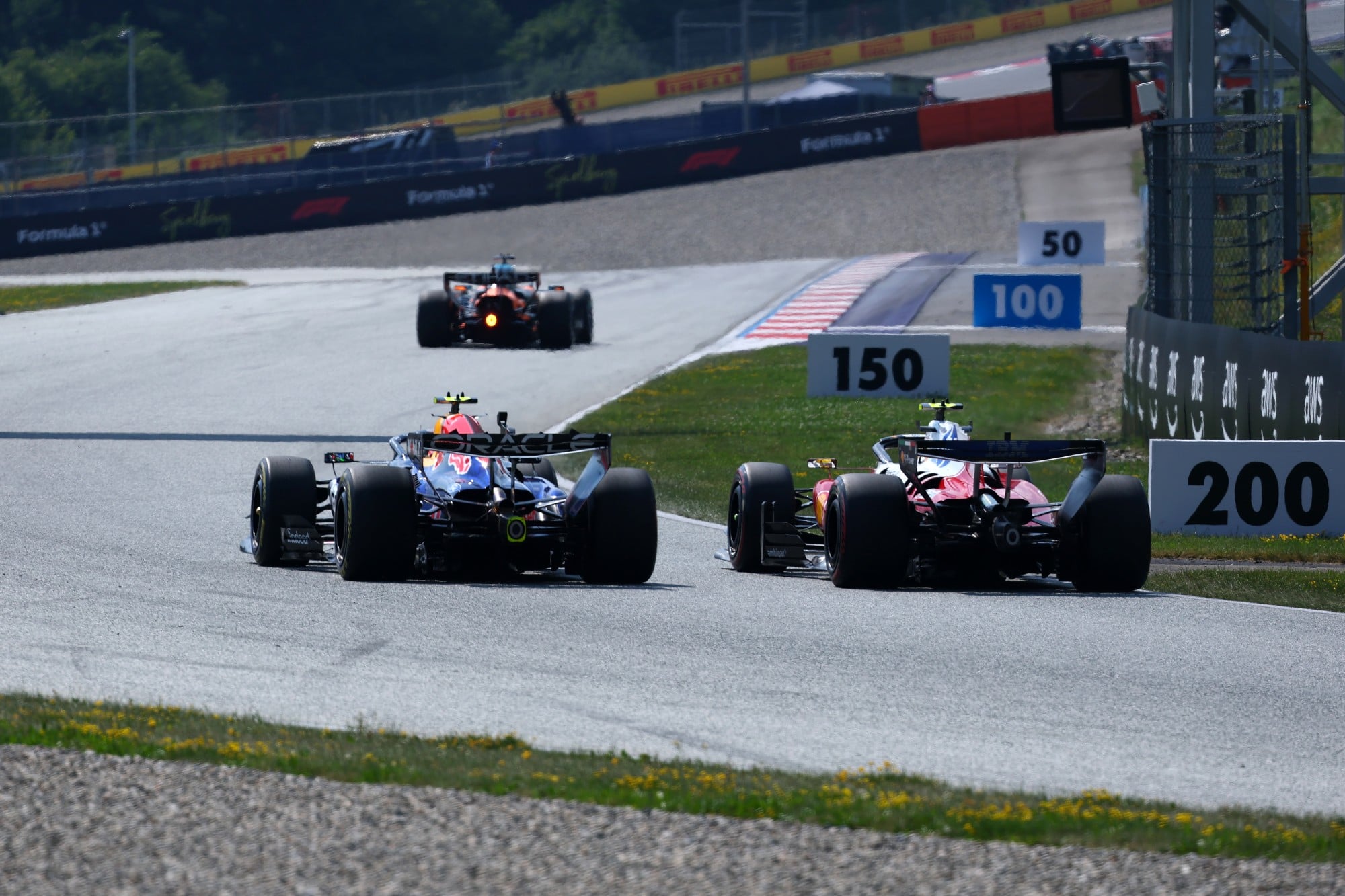 Lewis Hamilton (GBR) Scuderia Ferrari SF-26 and Isack Hadjar (FRA) Red Bull Racing RB22 battle for position.