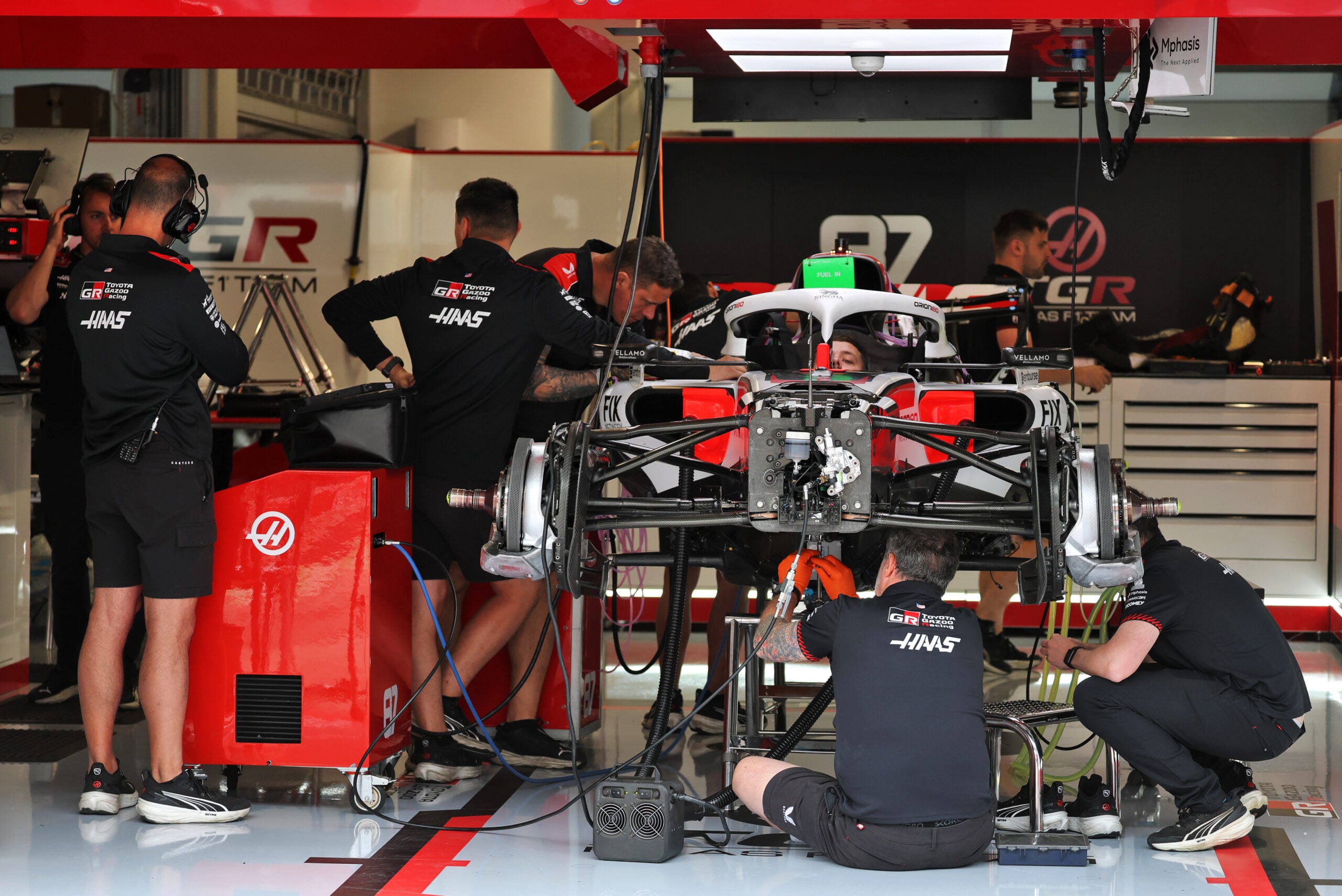 F1: Veja as fotos da quinta-feira do GP da Hungria 2026 Haas F1 Team VF-26 being prepared by mechanics in the pit garage.
