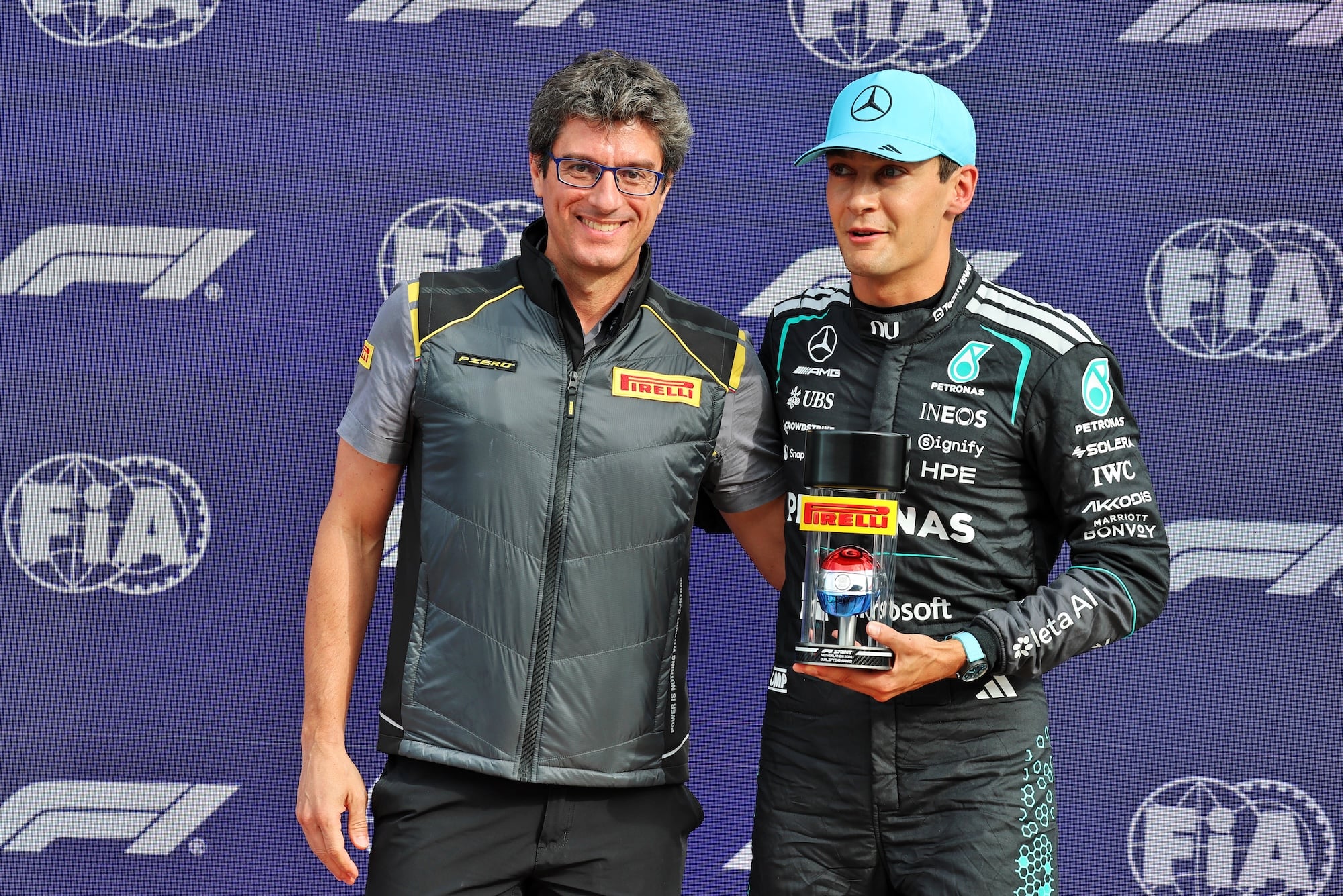 F1: Confira as imagens desta sexta-feira do GP da Holanda 2026 George Russell (GBR) Mercedes AMG Formula One Team (Right) celebrates his pole position in Sprint parc ferme with Dario Marrafuschi (ITA) Head of Pirelli Motorsport Business Unit..