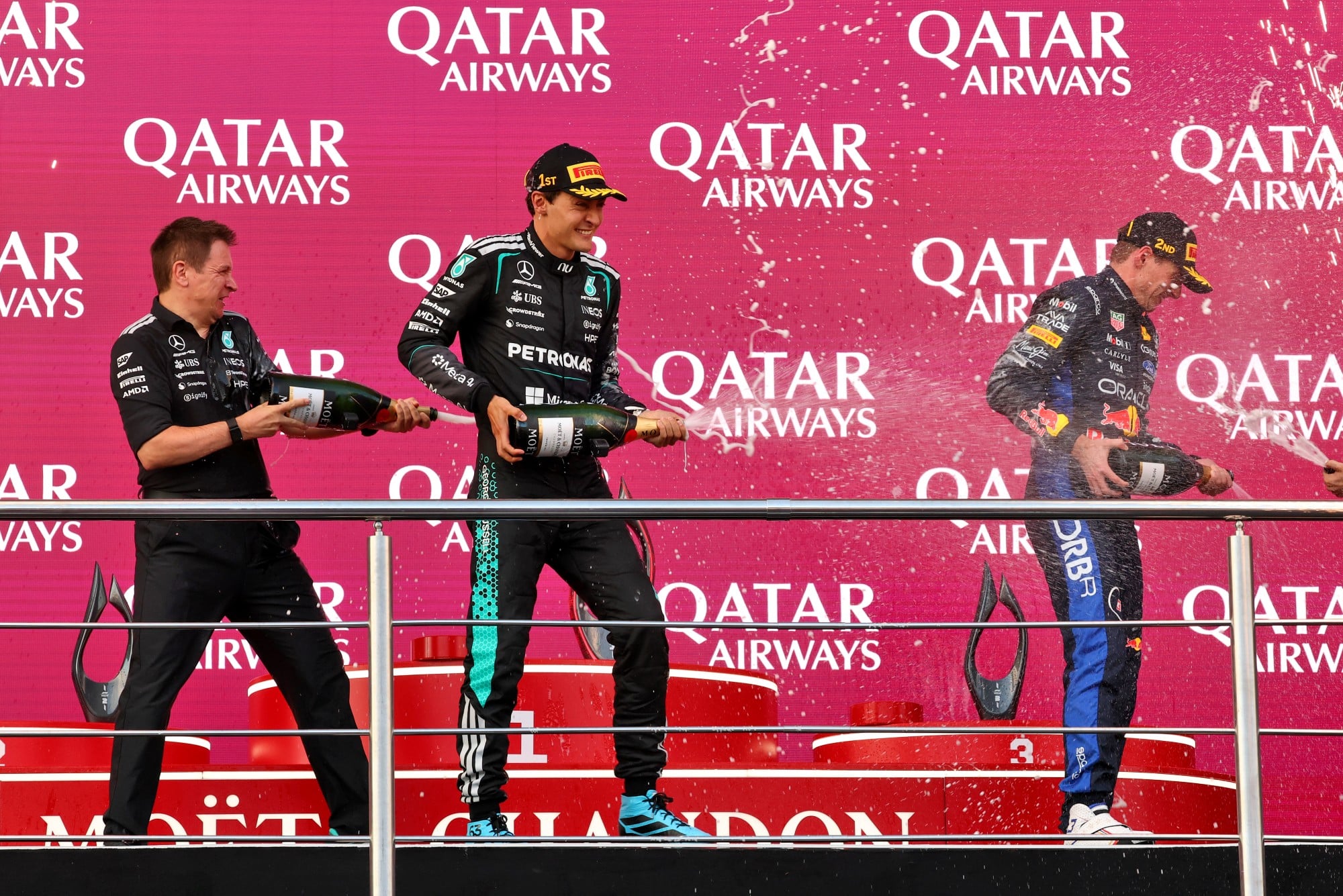 F1: Confira as fotos do GP do Azerbaijão 2026 (L to R): Chris Nelson (GBR) Mercedes AMG F1 Formula One Team F1 Trackside Control Systems Engineer celebrates on the podium with race winner George Russell (GBR) Mercedes AMG Formula One Team and second placed Max Verstappen (NLD) Red Bull Racing.