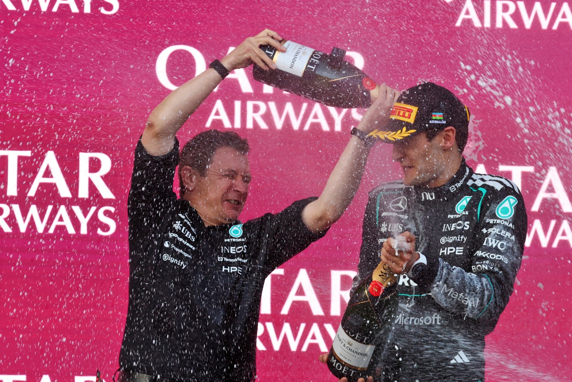 F1: Confira as fotos do GP do Azerbaijão 2026 (L to R): Chris Nelson (GBR) Mercedes AMG F1 Formula One Team F1 Trackside Control Systems Engineer celebrates on the podium with race winner George Russell (GBR) Mercedes AMG Formula One Team.